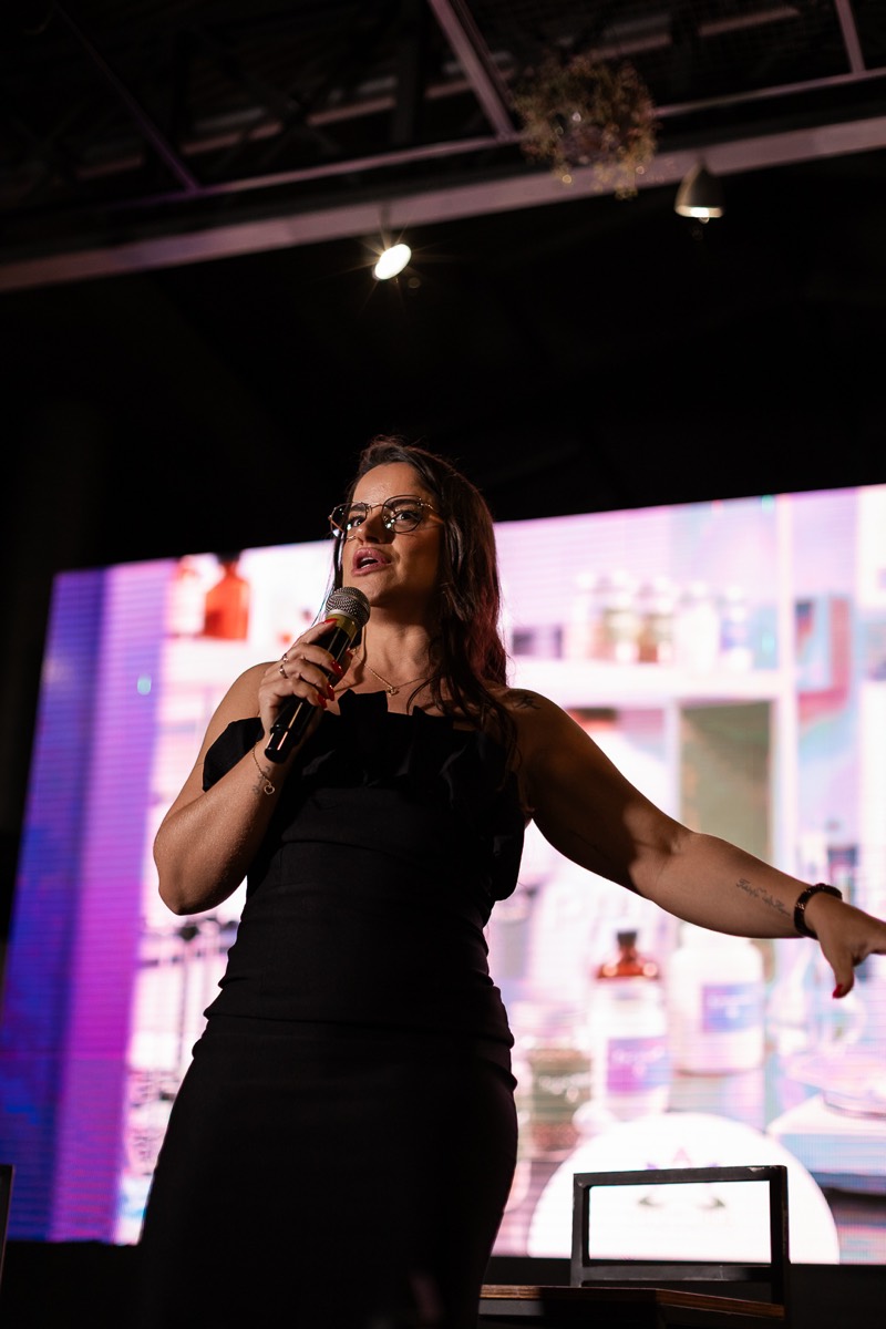 Francielle Caleffi falando ao microfone em um evento